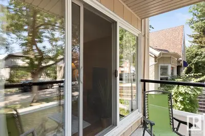 a sliding glass door on a porch with a chair at Condo Unit-UofA, UofA Hospital, Whyte Ave, Trails! in Edmonton