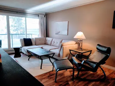 a living room with a couch and a table and chairs at Condo Unit-UofA, UofA Hospital, Whyte Ave, Trails! in Edmonton