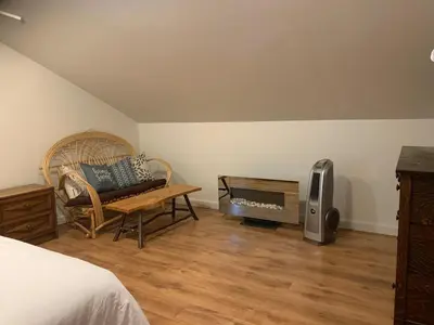 a bedroom with a bed and a couch and a fireplace at Entire Cordwood House 5 minutes south of town in Golden