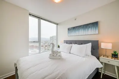 a bedroom with a white bed with a swan on it at Gorgeous Unit with Beautiful City Views in Vancouver