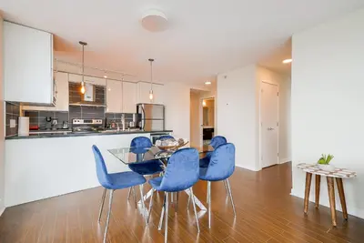 a kitchen and dining room with a glass table and blue chairs at Gorgeous Unit with Beautiful City Views in Vancouver