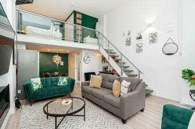 a living room with a couch and a staircase at Trendy Loft in Downtown in Vancouver