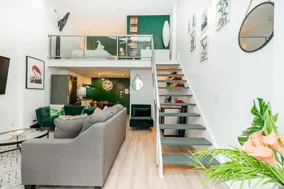 a living room with a loft bed and a staircase at Trendy Loft in Downtown in Vancouver