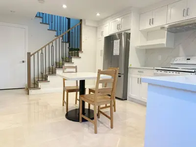 a kitchen with a table and chairs and a staircase at A Beautiful, cozy second floor room for staying in Vancouver