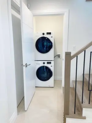 two washing machines in a white laundry room at A Beautiful, cozy second floor room for staying in Vancouver