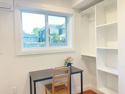 a desk with a chair in a room with a window at Brand new, cozy first floor room for staying in Vancouver