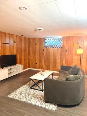 a living room with a couch and a tv at The house Londonderry mall in Edmonton