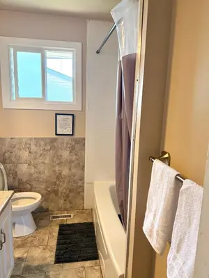 a bathroom with a tub and a toilet and a sink at The house Londonderry mall in Edmonton