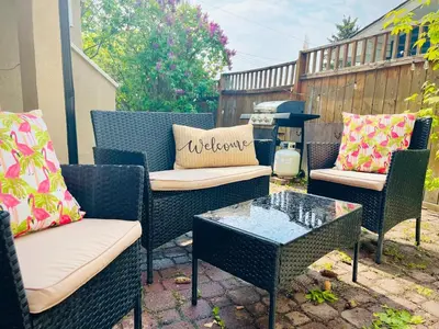 a patio with chairs and a table and a grill at The Chimney Studio with Gigantic Outdoor Fireplace in Calgary