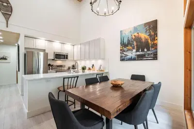 a kitchen and dining room with a wooden table and chairs at Painted Cliff by Outpost Whistler in Whistler