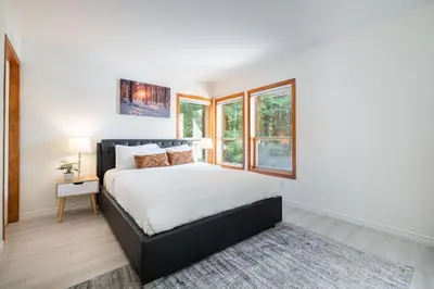 a bedroom with a large bed and windows at Painted Cliff by Outpost Whistler in Whistler
