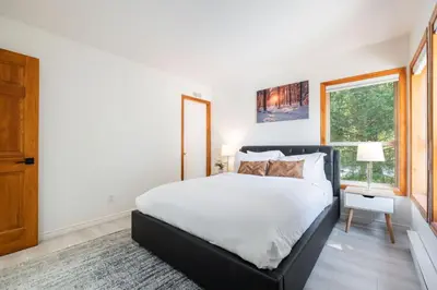 a bedroom with a large bed and a window at Painted Cliff by Outpost Whistler in Whistler