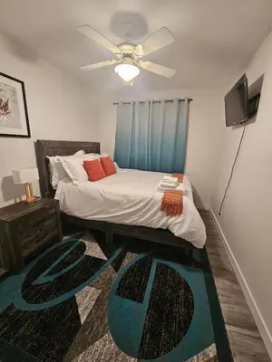 a bedroom with a bed and a ceiling fan at Aansel Suites QUEEN ROOM in Edmonton