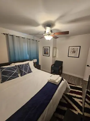 a bedroom with a bed and a ceiling fan at Aansel Suites QUEEN ROOM in Edmonton