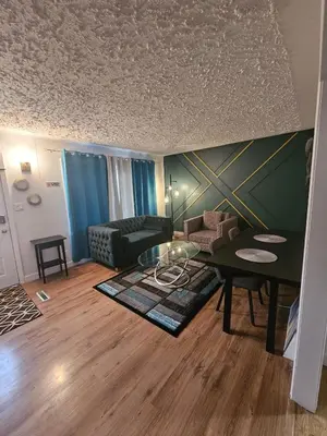 a living room with a table and a couch at Aansel Suites QUEEN ROOM in Edmonton