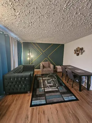 a living room with a couch and a table at Aansel Suites QUEEN ROOM in Edmonton