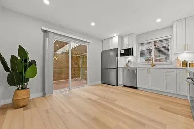 a kitchen with stainless steel appliances and a potted plant at Vancouver Lake City Way Guesthouse 10 min to SkyTrain in Burnaby