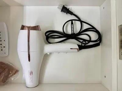 a white hair dryer with a cord on a wall at Vancouver Lake City Way Guesthouse 10 min to SkyTrain in Burnaby