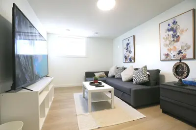 a living room with a couch and a flat screen tv at Quiet Family Friendly, 4 min UofC and University District Shops, 9 min DT in Calgary