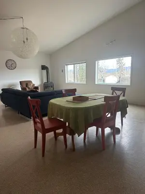 a living room with a table and chairs and a couch at Mezzanine Loft Above the Barn in Whitehorse