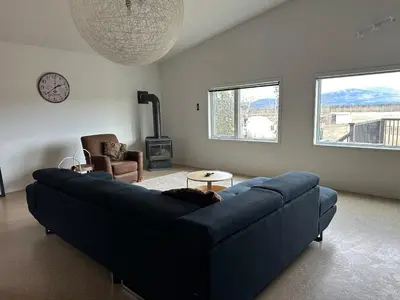 a living room with a blue couch and a fireplace at Mezzanine Loft Above the Barn in Whitehorse