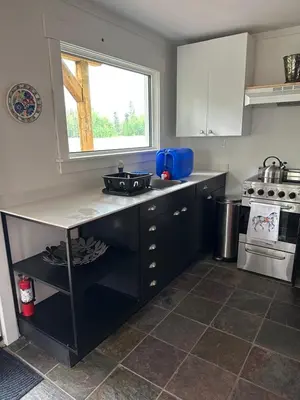 a kitchen with a sink and a stove and a window at Cabin with Fields of Dreams in Whitehorse