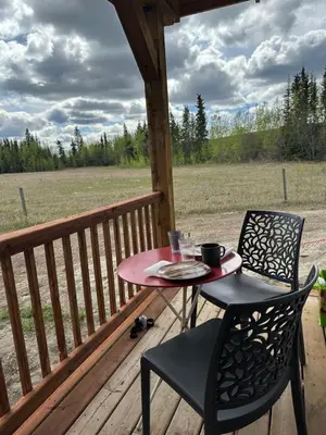 a table and two chairs on a porch with a table and chairs at Cabin with Fields of Dreams in Whitehorse