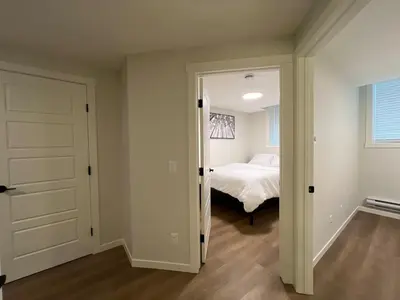 a bedroom with a bed and a door leading into a room at Deluxe 2-Bedroom Getaway Near Calgary Airport Sleeps Up to 6 in Calgary