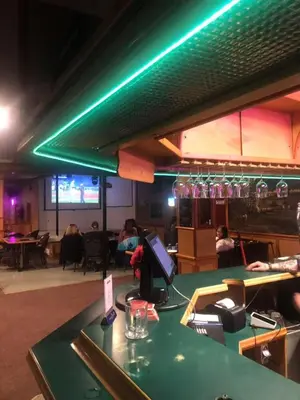 a bar in a restaurant with a green light at Valemount Hotel in Valemount