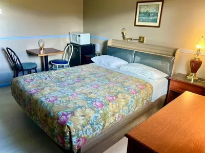 a bedroom with a bed and a table and chairs at Valemount Hotel in Valemount
