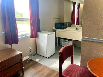 a small kitchen with a refrigerator and a sink at Valemount Hotel in Valemount