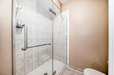a bathroom with a shower and a toilet at Cozy bedroom in quiet community in Calgary