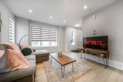 a living room with a tv and a couch and a table at ExoticLUSHquietRetreatKingBed|WIFI|Parking|WEM in Edmonton