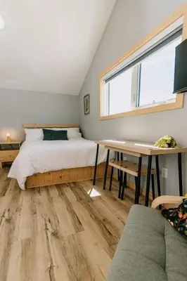 a bedroom with a bed and a desk and a window at Bikepack Basecamp in Nordegg