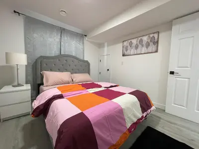 a bedroom with a bed with a colorful blanket at Comfy 2 Bedroom Suite Getaway in Edmonton