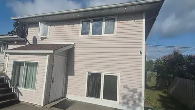 a small white house with a door and windows at The Peaceful Pines in Terrace