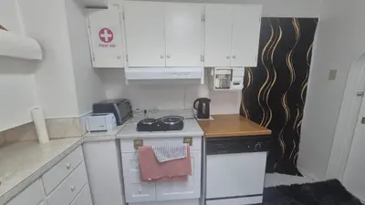 a small kitchen with white cabinets and a stove at The Peaceful Pines in Terrace