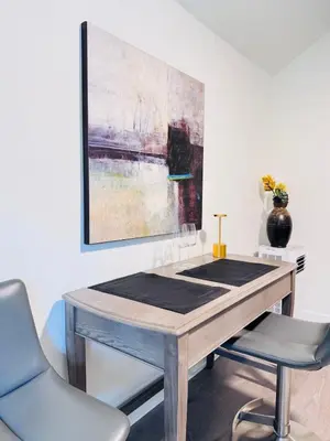 a table with two chairs and a painting on the wall at Charming Queen Bedroom with Bathroom Vancouver West in Vancouver