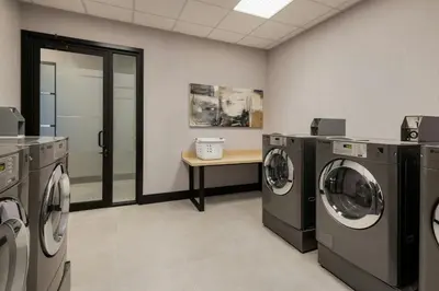 a laundry room with washing machines and a table at TownePlace Suites by Marriott Chilliwack in Chilliwack