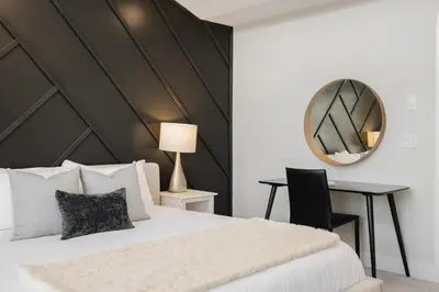 a bedroom with a bed and a mirror and a desk at Home Theater with AC, Dual Master Suites, BBQ in Calgary