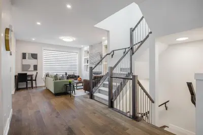a living room with a staircase and a couch at Home Theater with AC, Dual Master Suites, BBQ in Calgary