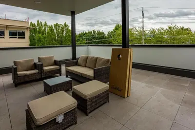 a balcony with wicker chairs and tables and windows at Gyrobeachescape in Kelowna