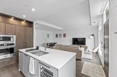 a kitchen with a sink and a living room at Gyrobeachescape in Kelowna