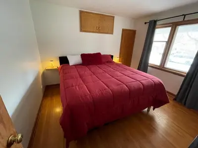 a red bed in a room with a window at Merlot House in Calgary
