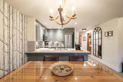 a dining room with a table and a kitchen at Arrowhead Point 2 by Outpost Whistler in Whistler