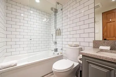 a bathroom with a toilet and a tub and a sink at Arrowhead Point 2 by Outpost Whistler in Whistler