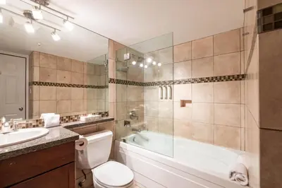 a bathroom with a tub and a toilet and a sink at Aspens Lodge 220 by Outpost Whistler in Whistler