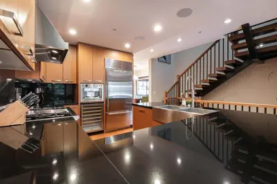 a kitchen with stainless steel appliances and a staircase at Fitzsimmons Walk 10 by Outpost Whistler in Whistler