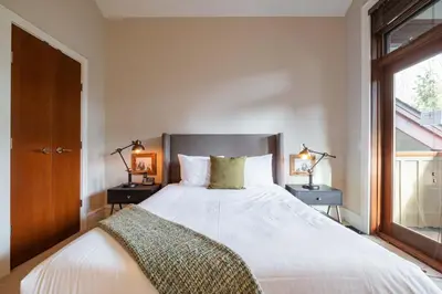 a bedroom with a large white bed with two night stands at Fitzsimmons Walk 10 by Outpost Whistler in Whistler