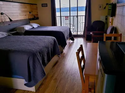 a hotel room with two beds and a television at Above Tide Motel in Campbell River